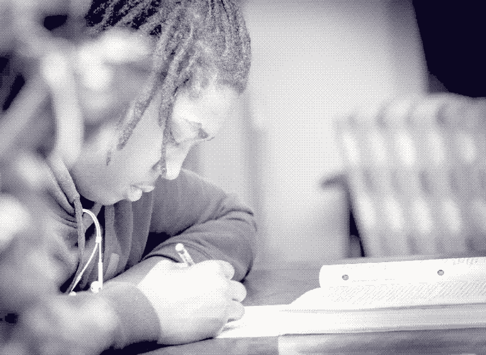 A clinician leaning over a desk, writing case notes by hand